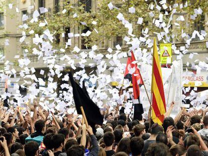 Los manifestantes lanzan papeletas en una protesta frente a la sede del PP en Cataluña.