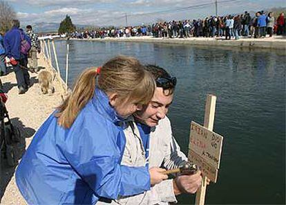 Una pareja coloca una estaca contra el Plan Hidrológico, en el <i>kilómetro cero</i> del travase del Ebro.