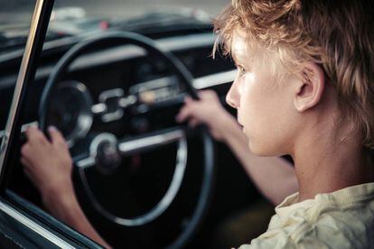 Un joven observa la carretera en el interior de un veh&iacute;culo.