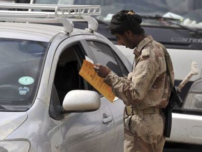 Un soldado yemen&iacute; inspecciona la documentaci&oacute;n en un puesto de control.