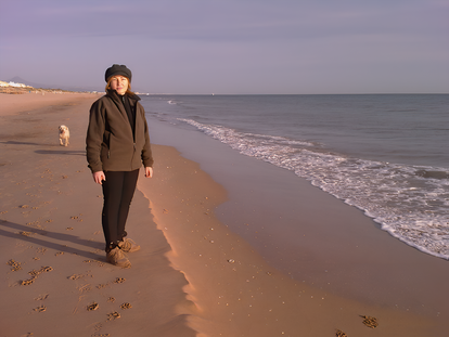 Teresa Vicetto, editora de 'El Cárabo', en la playa con su perra Canela.