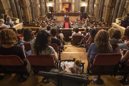 Una dona amb el seu fill segueix el ple especial al Parlament en defensa del moviment feminista.