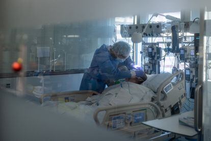 Un sanitario asiste a un enfermo de covid-19 en el Hospital Clinic de Barcelona, en diciembre de 2021.