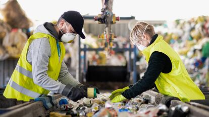 Dos empleados separan residuos para su reciclaje.