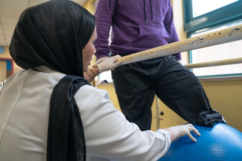 Rula Marahfeh hace ejercicios de movilidad con un paciente en la sala de fisioterapia del hospital. 