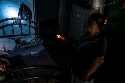 Teresa Zárate ilumina al interior de su casa, la comunidad se quedó sin servicios de iluminación y agua potable después del enfrentamiento.