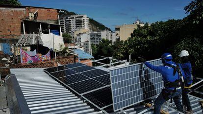 Trabajadores de la organización sin fines de lucro Revolusolar instalan paneles solares en una favela en Río de Janeiro (Brasil), el pasado 1 de marzo.