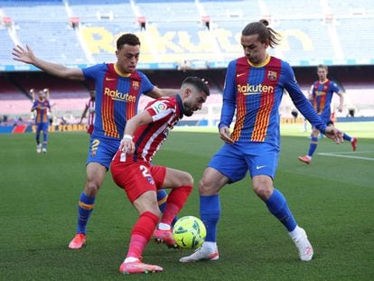 El centrocampista del Atlético Yannick Carrasco es presionado por Sergino Dest (a la izquierda) y Antoine Griezmann durante el Barcelona-Atlético del pasado sábado. / Albert Gea (REUTERS)