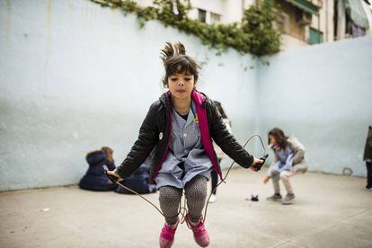 Cora salta a la comba en el recreo en su colegio.