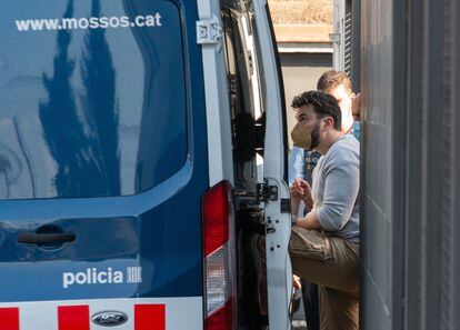 Uno de los detenidos es conducido a un furgón policial desde la comisaría de la Policía Local de Llinars del Vallés (Barcelona). EFE / Enric Fontcuberta