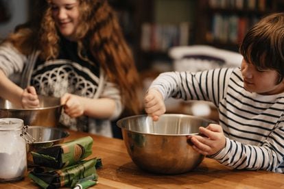 Un niño y una niña cocinan en su casa.