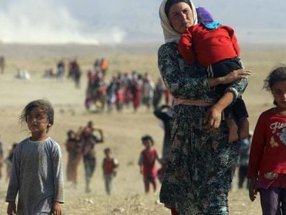 Desplazados yazid&iacute;es abandonan la ciudad de Sinjar, en agosto.