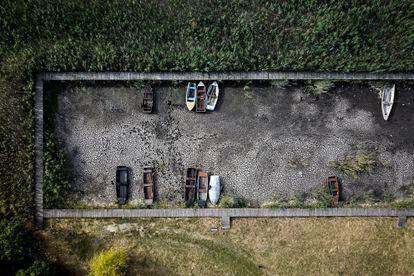 Aerial view of several boats on a dry lake bed in a port in Velence, Hungary in August. 