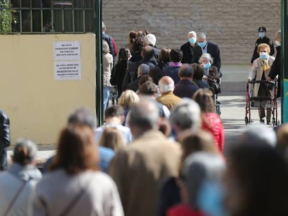 Decenas de personas hacen cola para votar en el Colegio Joaquín Turina de Arturo Soria, este martes. 