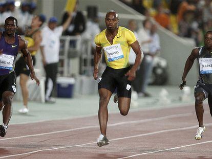 Powell, en el centro, durante la carrera de 100m en Doha.