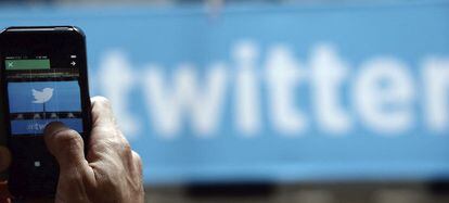 Un usuario toma una fotograf&iacute;a con su tel&eacute;fono del logotipo de Twitter.