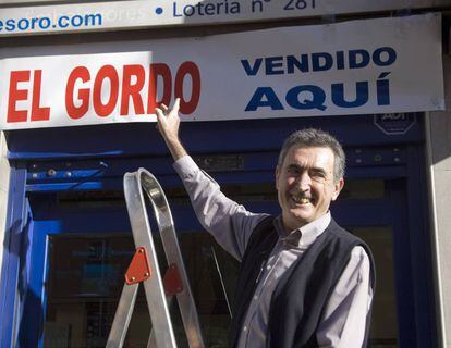 Avelino Rueda, dueño de una administración de lotería, colgaba el cartel de "El Gordo vendido aquí" en diciembre de 2008.
