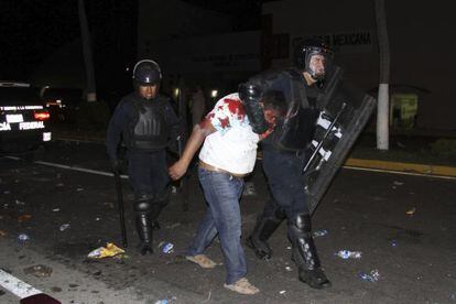 Un manifestante detenido por un polic&iacute;a en Acapulco. 