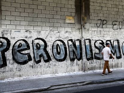 Un hombre pasa delante de un grafiti de propaganda que hace referencia al peronismo, en una calle de Buenos Aires