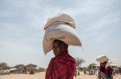 Asetta Noor transportaba el miércoles dos sacos de granos recibidos tras un reparto de ayuda del Programa Mundial de Alimentos en el campamento de refugiados de Fourkoulom, en Baga Sola, Chad.