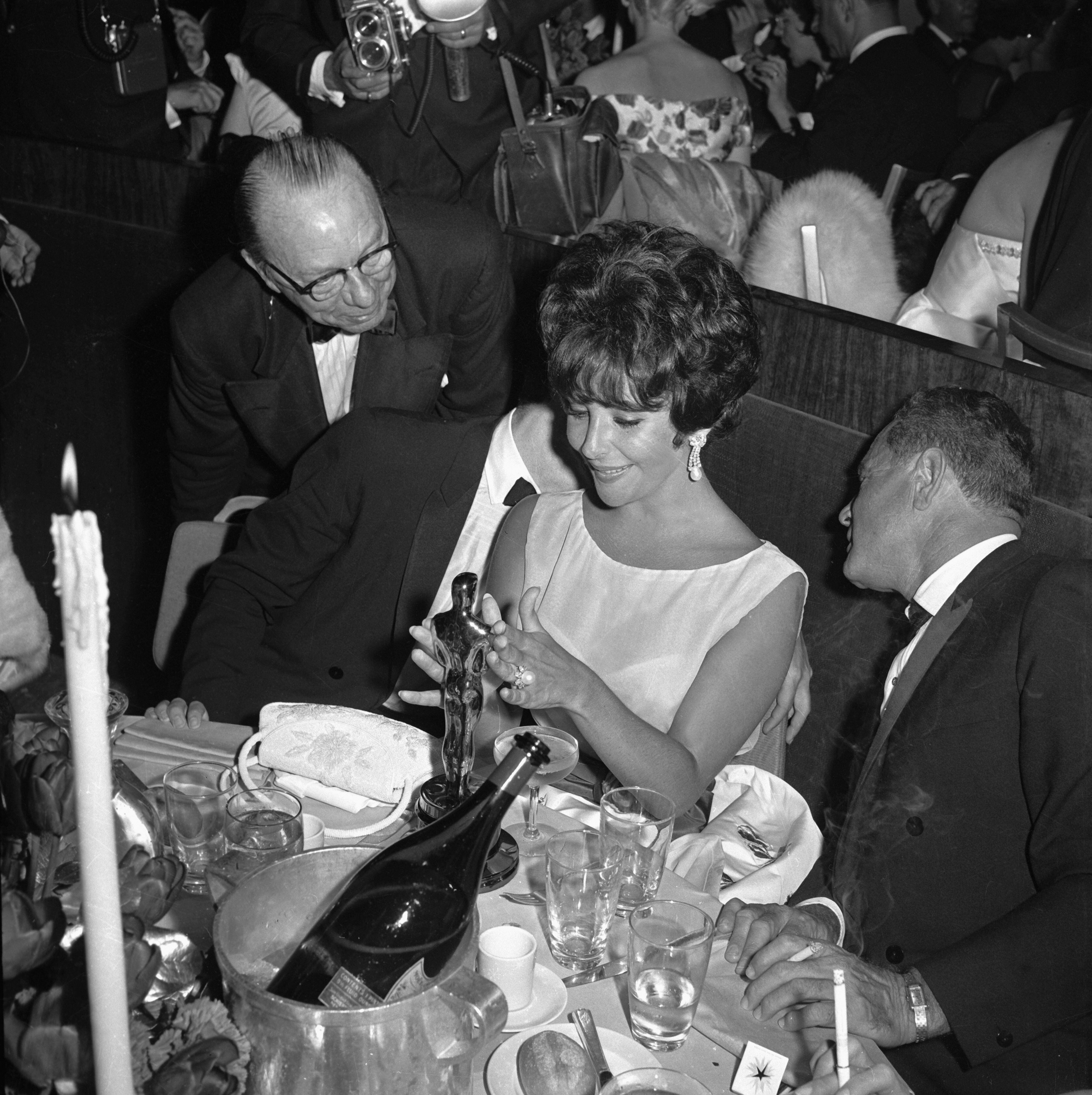 Elizabeth Taylor admira su primer premio Oscar en una fiesta tras la gala. La actriz ganó su primera estatuilla en 1960 por la película 'Una mujer marcada'. Ver a las grandes estrellas de la época era un aliciente para ver estas ceremonias.