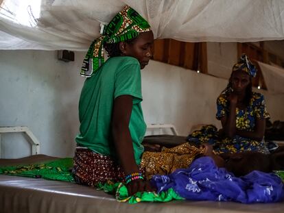 Djeuda Mussa cuida de su hija, Ada, de un año y enferma de rubeola, en el hospital de Mora, en Camerún. Al fondo, la abuela de la niña acompaña.