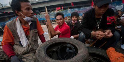 Un grupo de  <i>camisas rojas</i> descansa tras una barricadas en un campamento levantado en Bangkok.