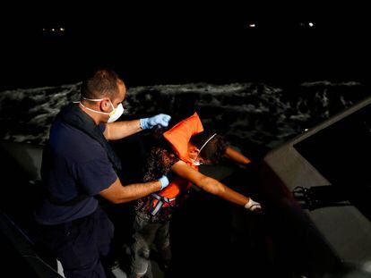 Un migrante tunecino es ayudado por un oficial maltés.