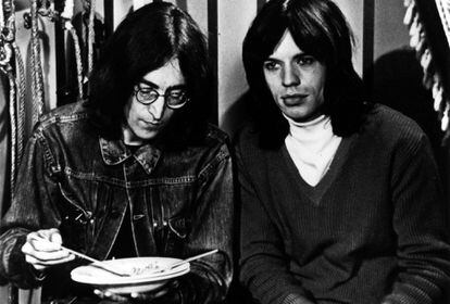 El vocalista de 'The Beatles', John Lennon, comiendo al lado de Mick Jagger.