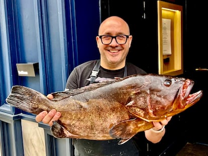 El cocinero Carlos del Portillo con un mero amarillo a las puertas de su restaurante Bistronómika, en Madrid.
