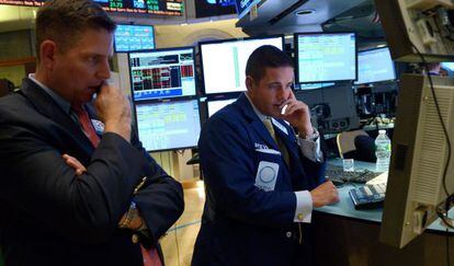 Empleados y corredores de Wall Street guardan un minuto de silencio en memoria de las víctimas del tiroteo en la escuela en Newtown.