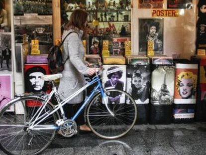 Una chica ojea discos de vinilo junto a su vieja bicicleta. 