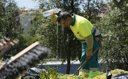Un jardinero de Madrid se refresca durante la ola de calor de este verano.