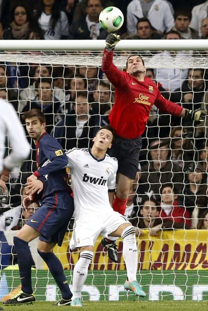 Pinto despeja un balón ante Mesut Özil y su compañero Gerard Piqué.