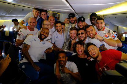 Los jugadores del Sevilla posan con el trofeo, durante el trayecto de vuelta de Budapest.