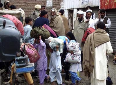 Los habitantes de Mingora (noroeste de Pakistán) cargan con sus pertenencias y abandonan sus casas para escapar del ataque del Ejército.