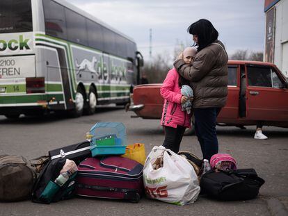 Una mujer junto a su hija y sus pertenencias llora mientras espera un autobus para ser evacuadas, en Kramatorsk (Ucrania).