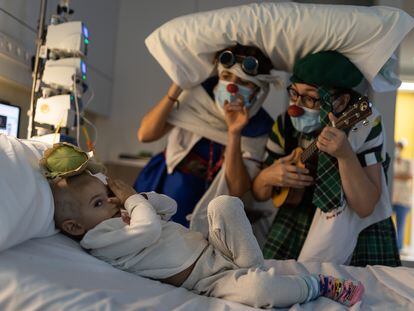 Luis Escuder, de dos años y medio, juega con unas payasas de la ONG Pallapupas en su habitación del Sant Joan de Déu Pediatric Cancer Center.