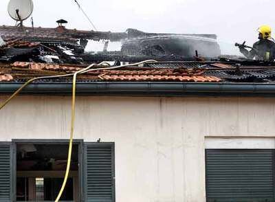 Un bombero trabaja en el tejado, gravemente dañado, de la vivienda de Bilbao La Vieja donde se originó el incendio.