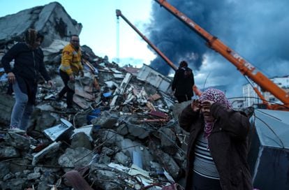 Una mujer llora junto a los restos de un edificio colapsado en la ciudad turca de Alejandreta. 