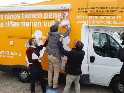 El presidente de Hazte Oír, Ignacio Arsuaga, coloca pegatinas en la caravana tránsfoba.