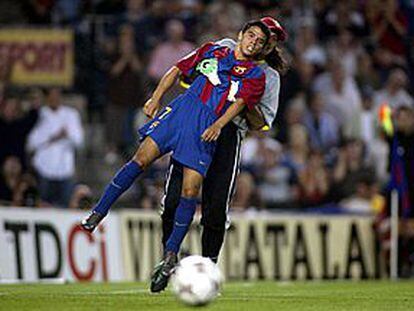 El Mono Burgos levanta a Saviola tras una acción del juego.