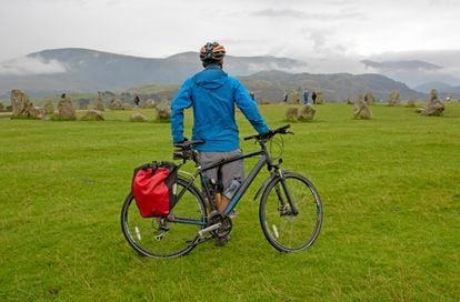 Inglaterra en bicicleta atravesando los Peninos. Cada año, entre 12.000 y 15.000 ciclistas cruzan algunos de los tramos más escarpados del país por la ciclovía del norte de Inglaterra Sea to Sea (C2C), sudando por los Peninos —la espina dorsal de Inglaterra— y pasando por el norte del Lake District National Park. Al subir el puerto de Whinlatter, antes de parar en el círculo de piedras de Castlerigg (en la foto), de 4.500 años —cerca de Keswick—, puede que el viajero dé gracias porque esta ruta solo tenga 225 kilómetros. Siempre es más recomendable ir de oeste a este con la esperanza de que el viento sople de espaldas Peninos arriba.