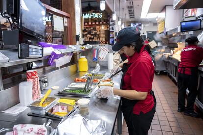 Una empleada prepara un perrito caliente en un restaurante de la cadena Portillo's, en Chicago (Illinois).