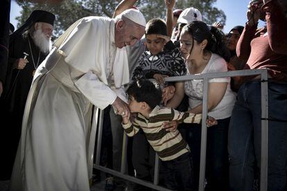 Un muchacho besa la mano al papa Francisco en el campo de refugiados de Moira, en la isla griega de Lesbos.