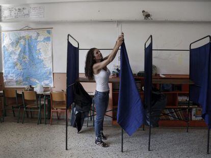 Una funcionaria coloca una cabina en un colegio en Atenas.