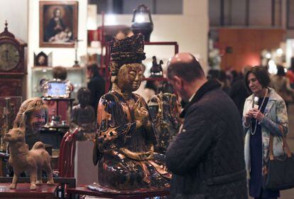 Un curioso observa la enorme figura del dios Abalositekebara, de madera lacada y oro, que representa al género masculino y femenino. El valor de este dios alcanza los 9.000 euros.