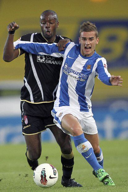 El delantero de la Real Sociedad Antoine Griezmann y el defensa del Granada Allan Romeo Nyom luchan por el balón.
