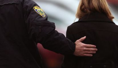 Un policía acompaña a una de las asistentes al funeral de Noah Pozner.