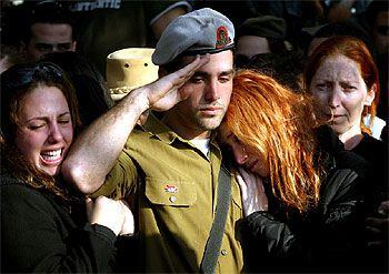 Un soldado israelí saluda durante el funeral por una víctima del atentado suicida del miércoles, ayer en Holon.